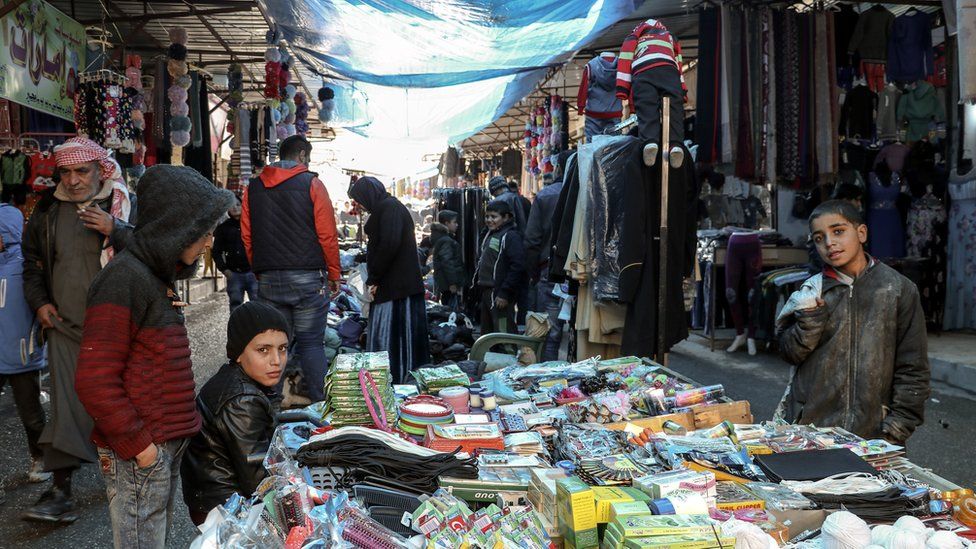 Syrians walk in a popular market in Manbij, northern Syria (31 December 2018)