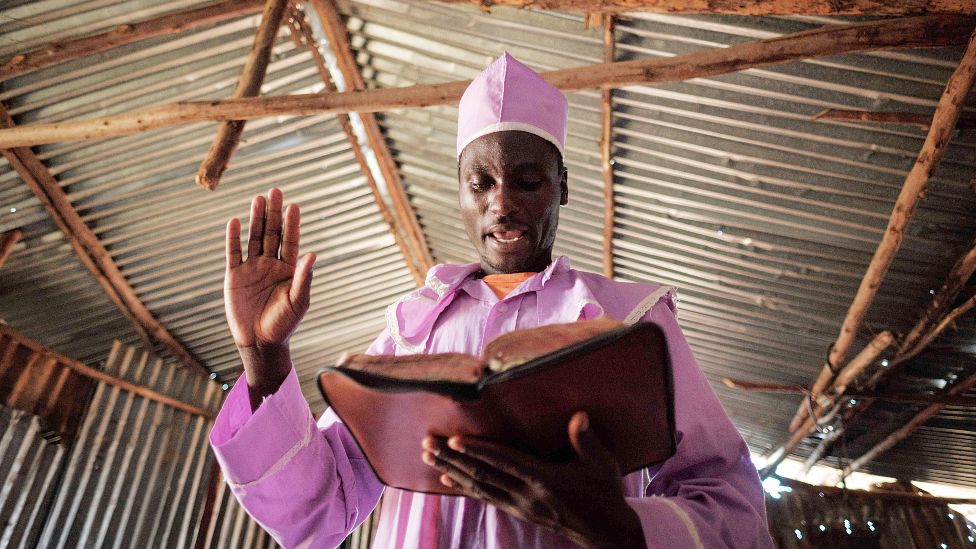 Прихожанин церкви Адундо Мессия читает Библию во время воскресной церковной службы в Кисуму, Кения