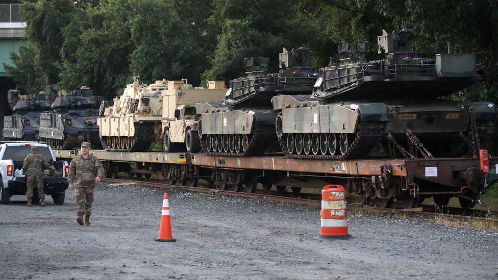 Two M1A1 Abrams tanks and other military vehicles sit on guarded rail cars at a rail yard on July 2, 2019 in Washington, DC