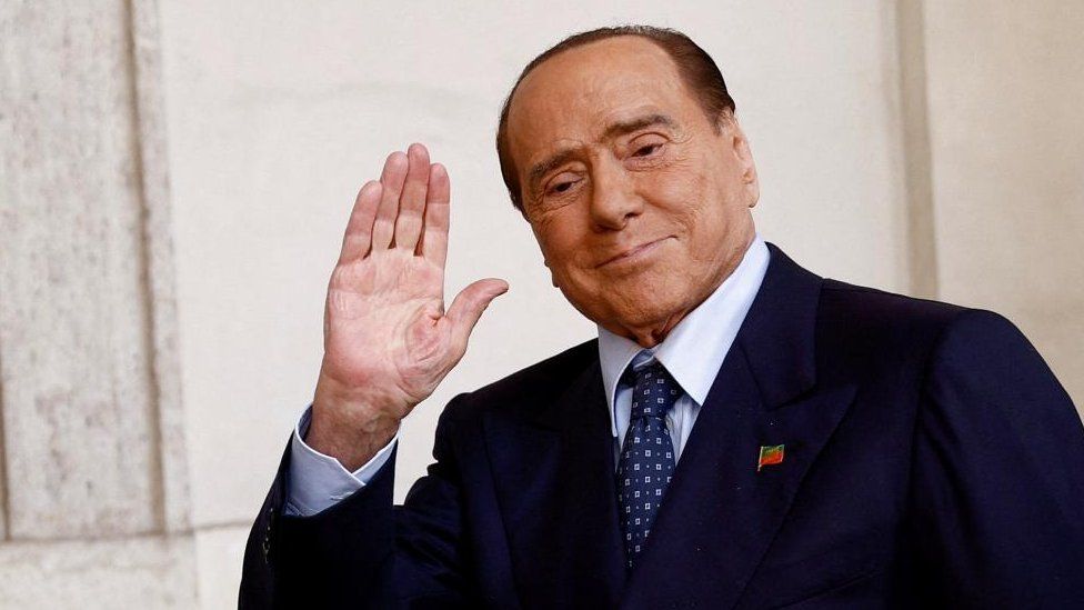 Silvio Berlusconi waves to a crowd