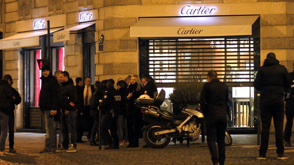Полиция стоит перед ювелирным магазином Cartier на Елисейских полях в Париже после ограбления в ноябре 2014 г.