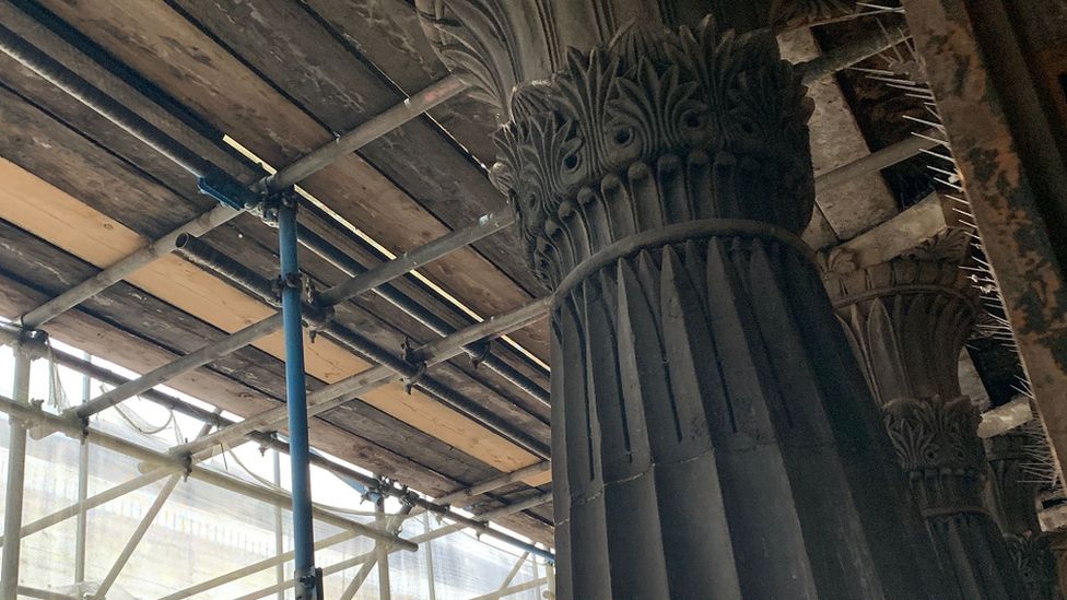 A column with scaffolding in the background