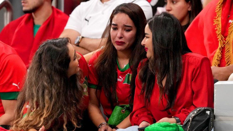 Moroccan fans comfort each other at the stadium in Qatar