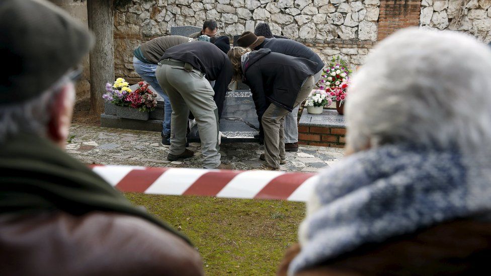 Ascension Mendieta (R) looks on as her father Timoteo's remains are exhumed at Guadalajara cemetery (19 Jan)