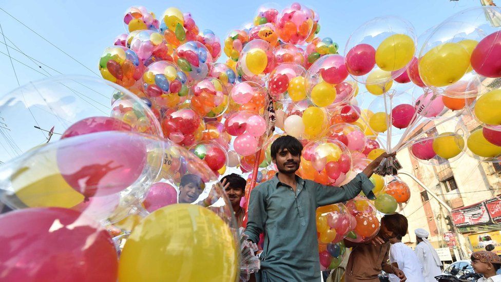 A man holding balloons in different colours in Karachi, Pakistan.