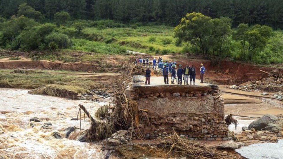 Timber company workers stand stranded on a damaged road on 18 March 2019, at Charter Estate in Chimanimani, eastern Zimbabwe.