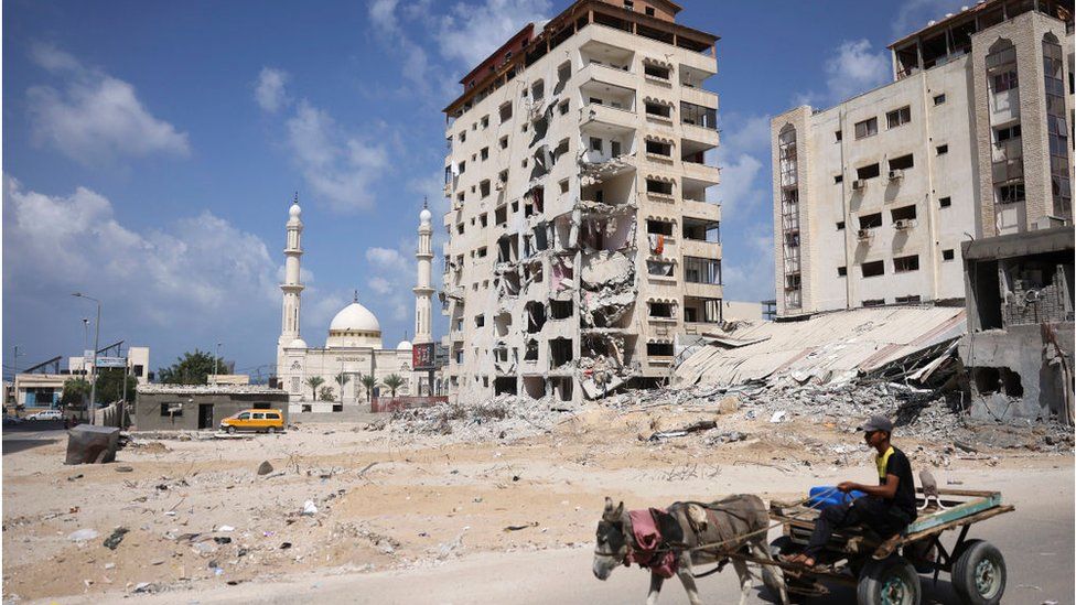 Donkey pulls man on a cart past damaged buildings in Gaza (23/09/21)