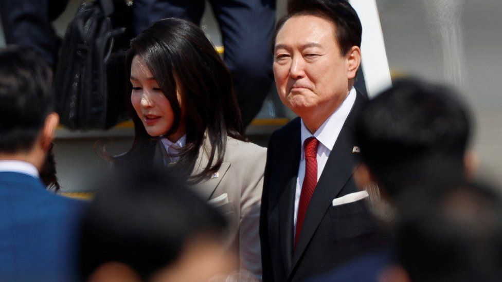 The president of South Korea and his wife greet people