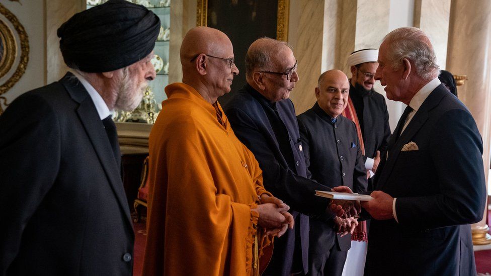 King Charles walks down a line of different faith leaders greeting them in a reception at Buckingham Palace after his accession to the throne.