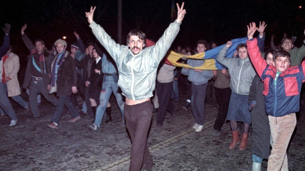 People celebrate after Romanian President Nicolae Ceausescu was overthrown in Bucharest, Romania, on 22 December 1989