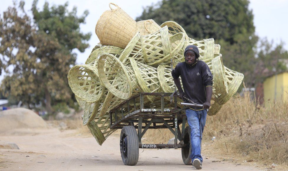 A man pulls a cart laden with reed chairs in an impoverished settlement of Hopley, Harare, Zimbabwe - Wednesday 23 June 2021