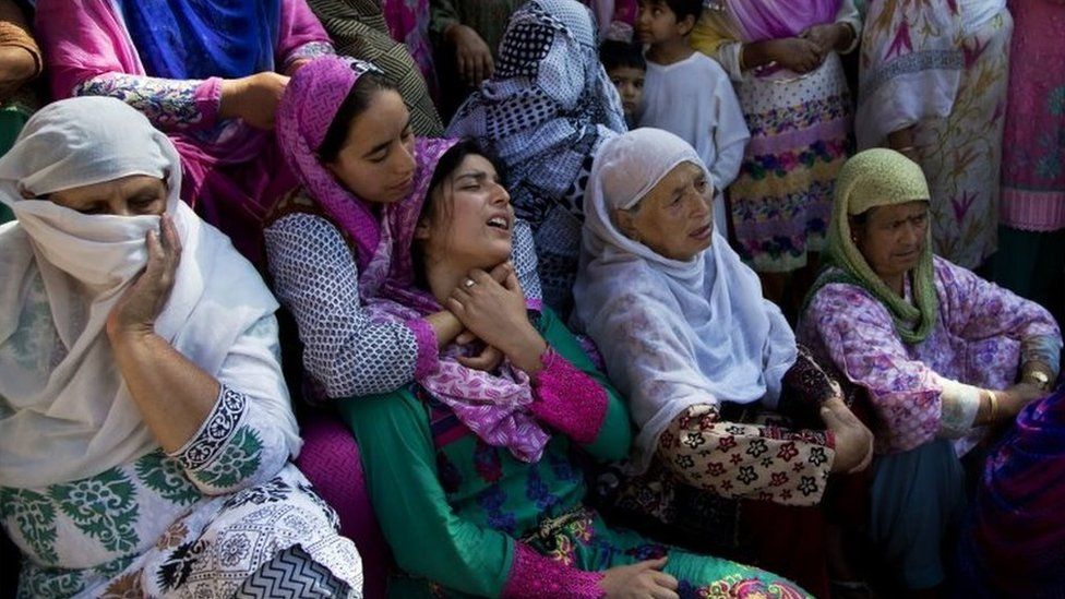 A woman comforts Jameela, centre, mother of Nasir Shafi, during his funeral procession on the outskirts of Srinagar, Indian controlled Kashmir, 17 September