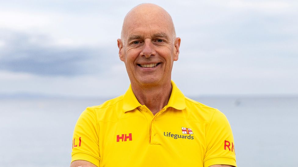 male lifeguard in his sixties with arms crossed