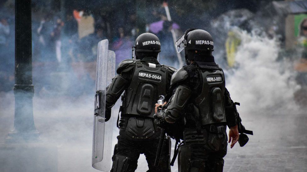 Riot police members contain protesters with tear gas and stun granades in Pasto Narino on 1 May 021.