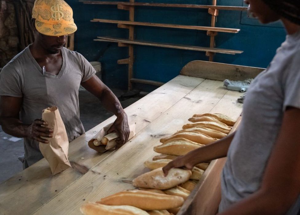 A customer buys bread at the South Street bakery, Antigua