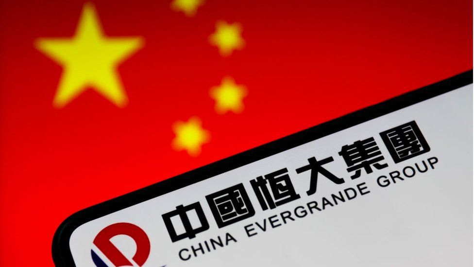 The evergrande logo is seen in front of a Chinese flag