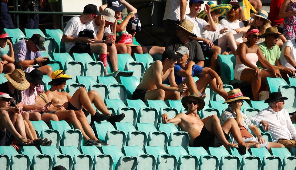 Spectators sit in the sun as Sydney experiences a heat wave during day four of the Fifth Test match in the 2017/18 Ashes Series between Australia and England at Sydney Cricket Ground, 7 January 2018