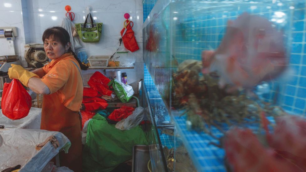 A woman selling fish at a market in Shanghai, China on 24 August