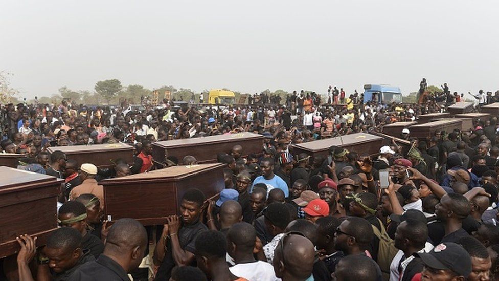 Pall bearers at a funeral service for people killed during farmer-herder violence in Nigeria in January