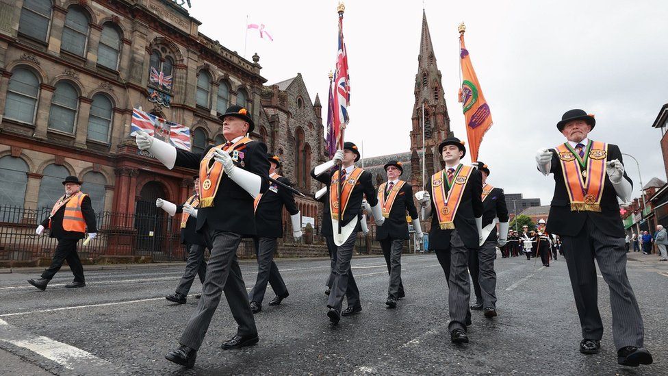 Members of the Orange Order passing an Orange Hall on Clifton Street in north Belfast