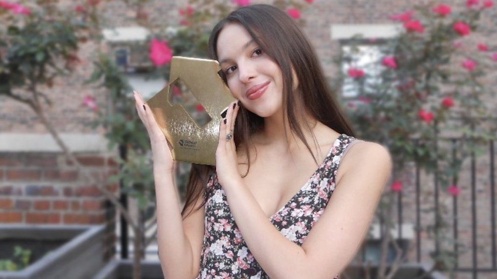 Olivia Rodrigo poses with her Official Chart award