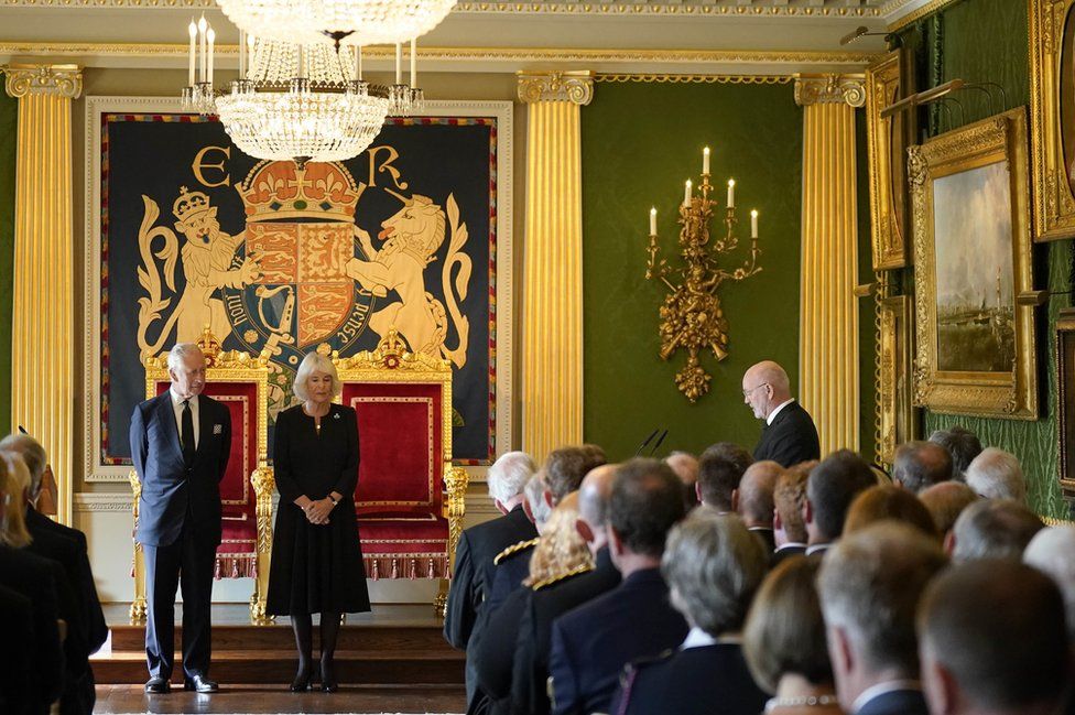 Alex Maskey delivers a message of condolence to King Charles and Camilla inside the Throne Room at Hillsborough Castle as guests watch the proceedings