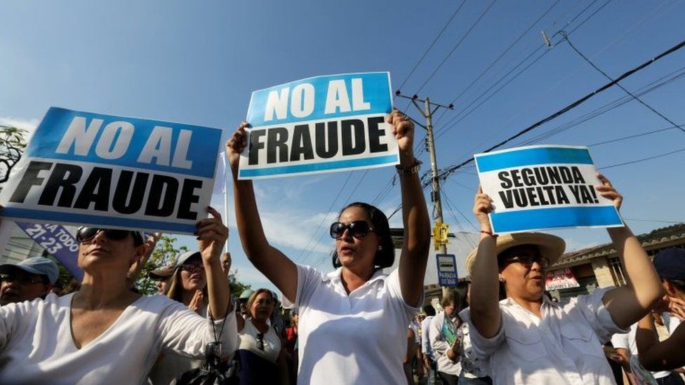 People hold signs reading "No to fraud" and "(Election) Run-off now" as they protest near the electoral council in Guayaquil, Ecuador February 20, 2017.