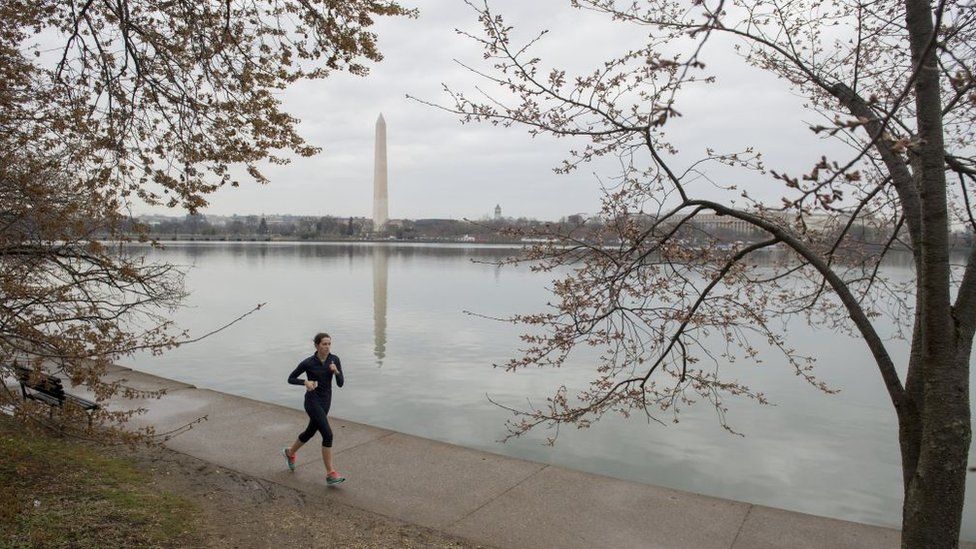 Woman jogs in DC with Washington Monument in background
