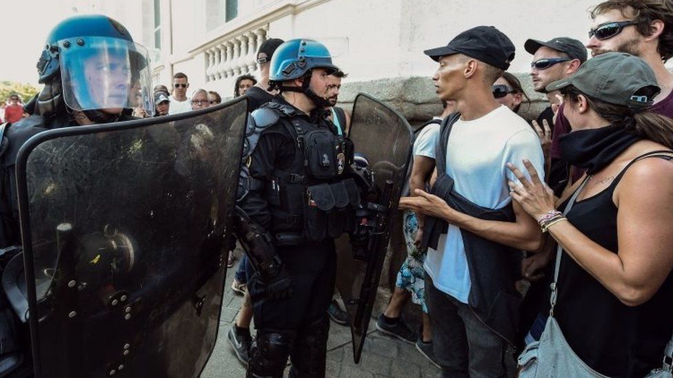 Riot police speak to people during a gathering in Nantes over the death of Steve Maia Caniço