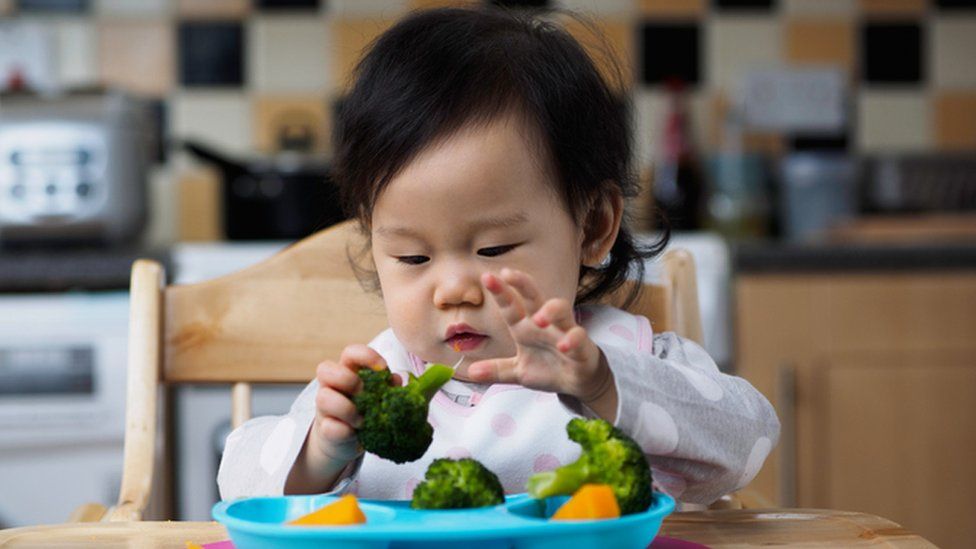 Baby girl eating vegetables