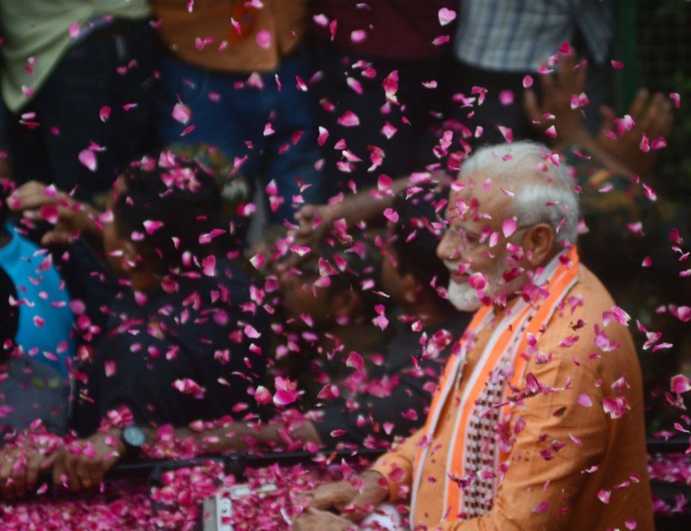 Indian Prime Minister Narendra Modi waves towards supporters during his road show in Varanasi on April 25, 2019 . PM Modi is visiting his parliamentary constituency Varanasi on April 25 and 26 .