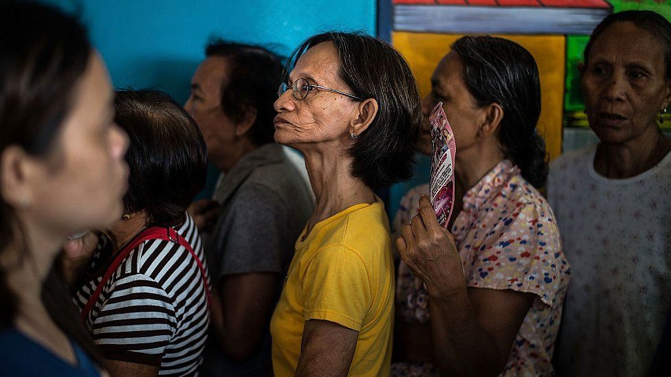 People stand in line to vote at a polling station on May 9, 2016 in Manila, Philippines.