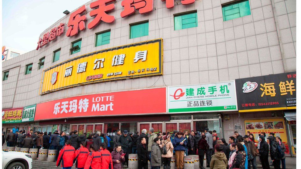 Китайцы стоят у закрытого магазина Lotte в Цзилине, провинция Цзилинь, Китай, 9 марта 2017 г.