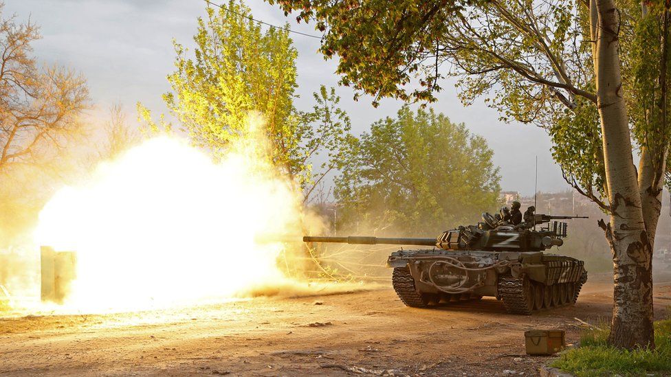 A tank fires in a burst of white-hot air