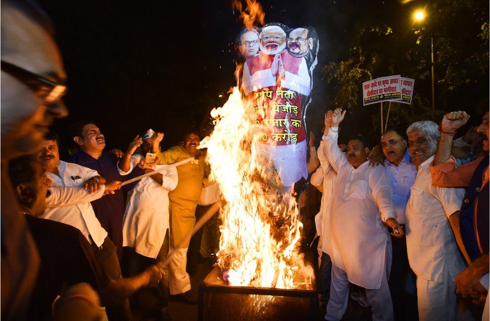 Congress workers, demanding a detailed investigation into corruption allegations against Jay Amit Shah, burn effigies of PM Modi, Amit Shah and Jay Shah during a protest on October 10, 2017 in Delhi