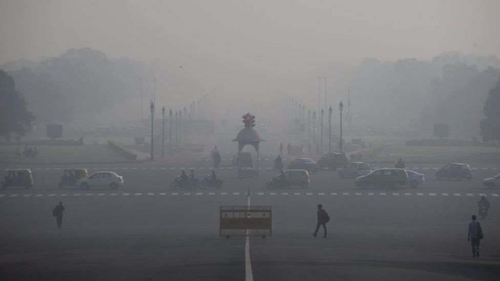 In this Nov. 24, 2015 photo, commuters walk as vehicles move at a traffic signal in New Delhi, India