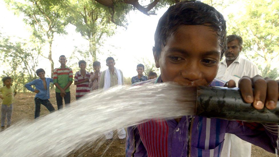 A child drinking from a pipe