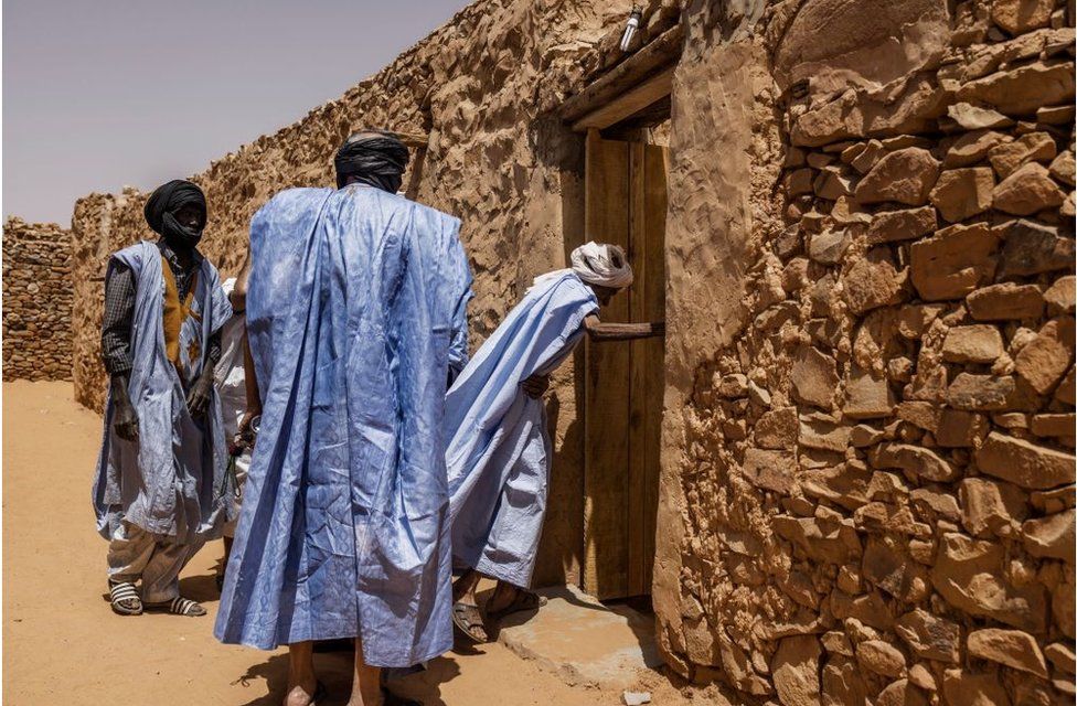 Men arrive at the Mosque in Chinguetti. They are wearing traditional blue kaftans.