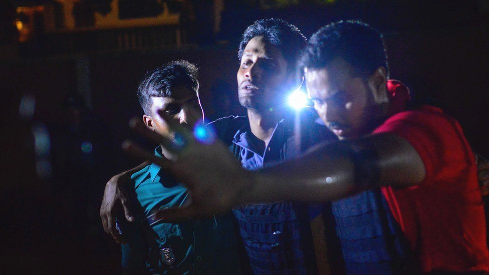 Bangladeshi policeman that was injured during an attack on an upscale restaurant is helped by others in Dhaka on July 1, 2016.