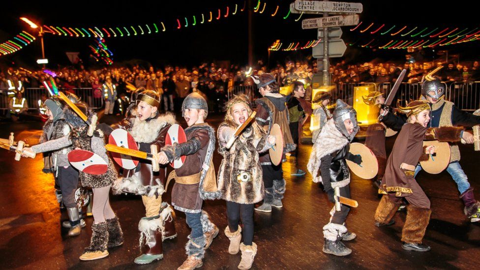 Children dressed in Viking costumes wielding toy swords