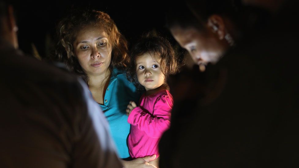 A two-year-old Honduran girl as her mother is searched and detained near the US-Mexico border on in McAllen, Texas, on 12 June 2018
