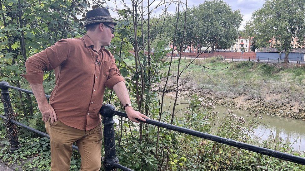 A man looking down into the River Avon