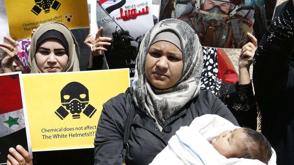 A woman with a baby in a crowd of protesters