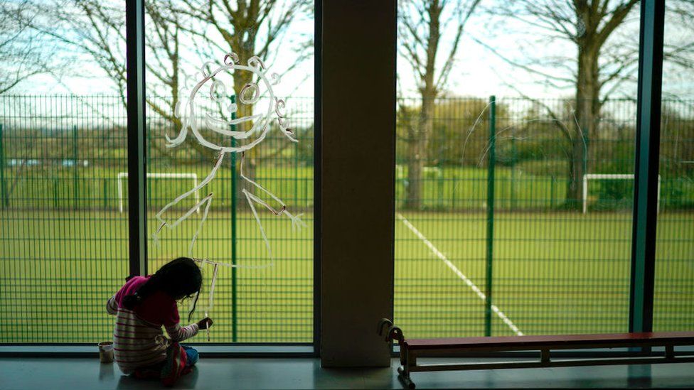 School pupil drawing on window