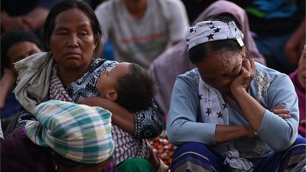 People wait at a temporary shelter in a military camp as they flee ethnic violence that has hit the northeastern Indian state of Manipur on May 7, 2023