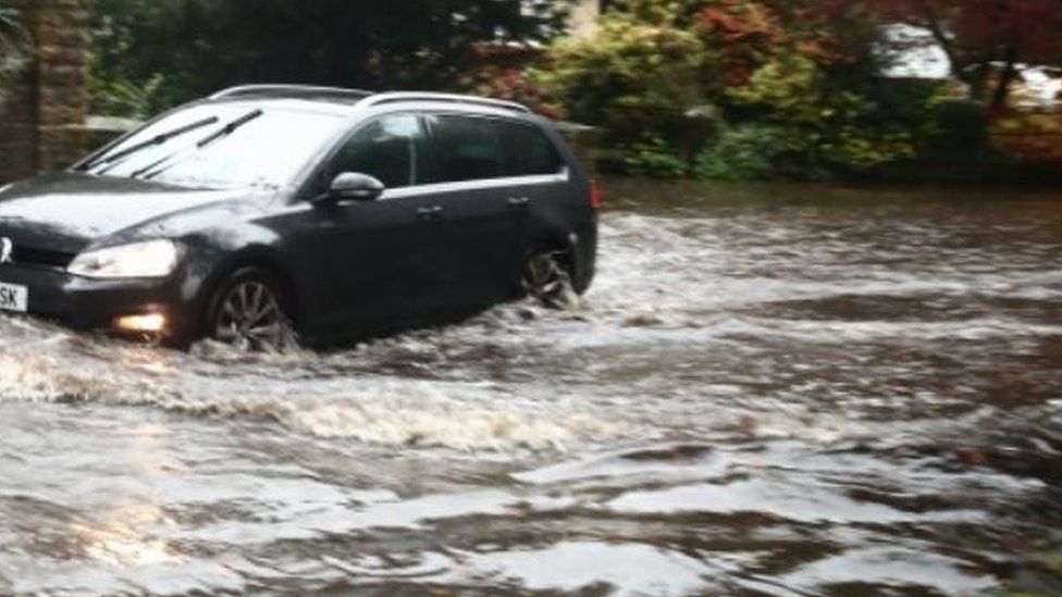 A car ploughs through flood water in Sheffield