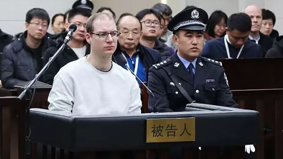Robert Lloyd Schellenberg (left) listens during his retrial in Dalian's court. Photo: 14 January 2019