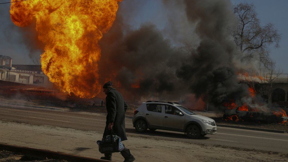 A man walks past a fire after a shelling, as Russia"s attack on Ukraine continues, in Kharkiv, Ukraine March 25, 2022