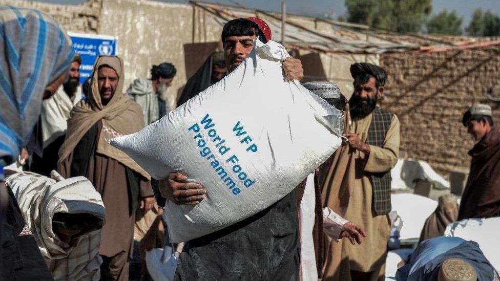 Man carrying food aid sack in Afghanistan