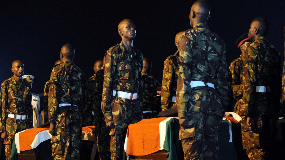 Kenyan soldiers by the coffins of colleagues killed in Somalia